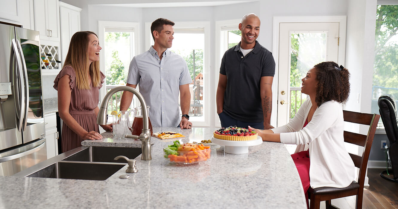 Two Couples Talking In A Kitchen