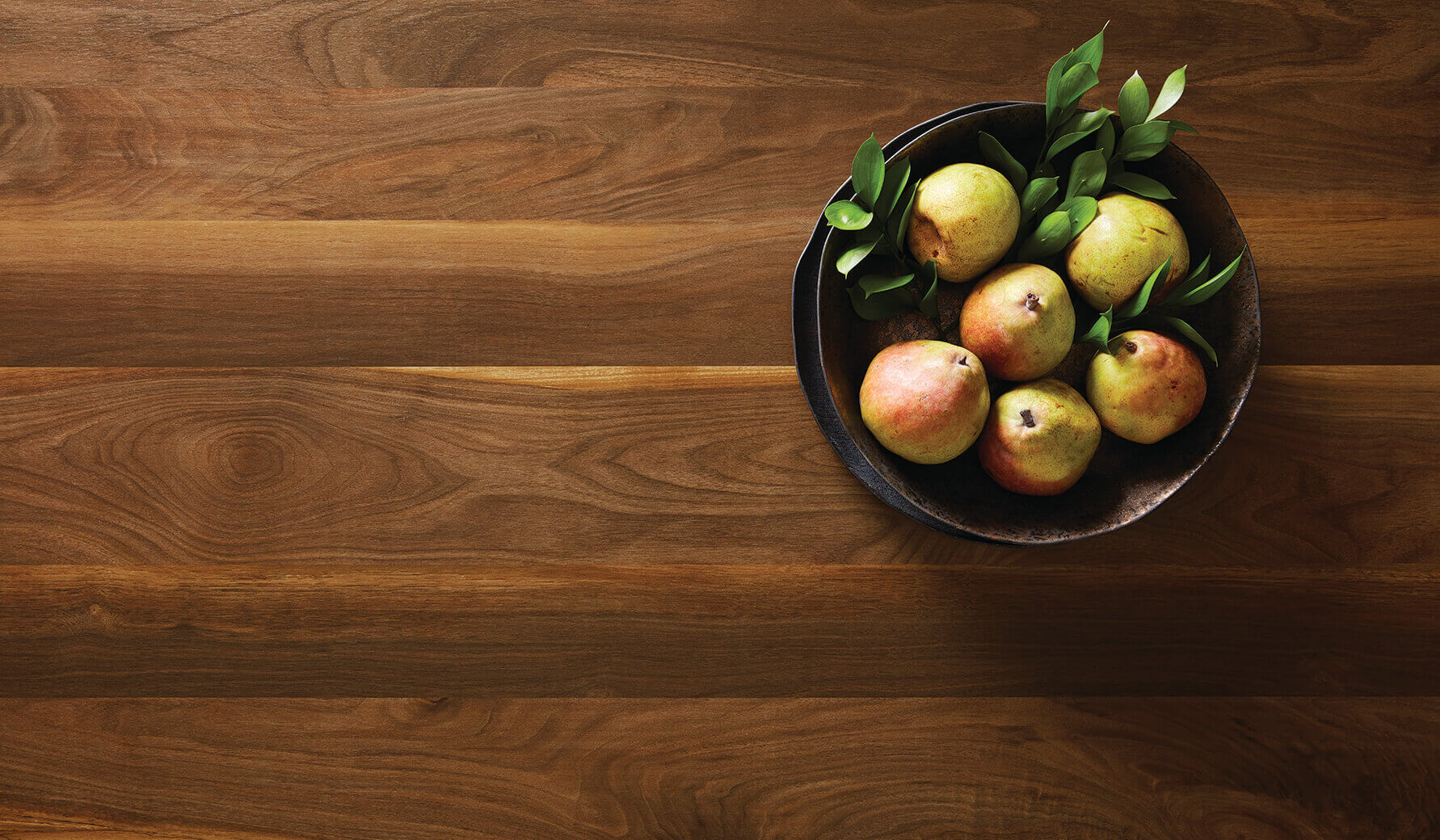 Wide Planked Walnut Laminate Countertop With A Bowl Of Pears